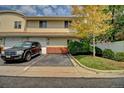 Tan two-story townhouse with attached garage and landscaping at 7450 Lowell Blvd # A, Westminster, CO 80030