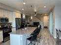 Open concept kitchen with island, stainless steel appliances, and grey countertops at 12261 Karls Ln, Northglenn, CO 80241