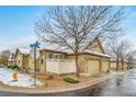 Rear view of the home showcasing the garage and a private yard at 8436 W Quarles Pl, Littleton, CO 80128