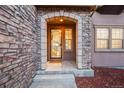 Inviting entryway with stone accents and a glass front door at 10577 Summersong Way, Highlands Ranch, CO 80126