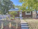 Cute brick home with a well-maintained lawn and walkway at 924 Malley Dr, Northglenn, CO 80233