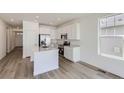 Modern kitchen with white cabinets, island, and stainless steel appliances at 5137 N Quemoy St, Aurora, CO 80019