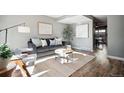 Bright living room featuring a gray couch and wood floors at 2105 Coronado Pkwy # C, Denver, CO 80229