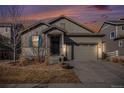 Inviting home exterior at dusk with warm lighting and a cozy atmosphere at 7285 S Titus Way, Aurora, CO 80016