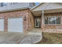 Brick front entry with a porch and three-car garage at 2078 Gold Finch Ct, Longmont, CO 80503