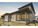 Two-story house with gray siding, covered patio, and landscaped yard at 11575 Toccata Trl, Parker, CO 80134