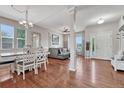 Open living room with hardwood floors, a gray sectional sofa, and a dining area at 12282 Rockdale St, Parker, CO 80138