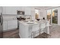 Modern kitchen with island, stainless steel appliances, and white cabinetry at 15881 Willow Way, Thornton, CO 80602