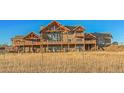 Stunning log home exterior with multiple decks and expansive views at 15958 Shadow Mountain Ranch Rd, Larkspur, CO 80118