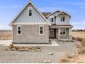 Two-story home with light gray siding and stone accents at 16475 Essex S Rd, Platteville, CO 80651