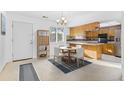 Bright kitchen and dining area with wood cabinets and a breakfast bar at 9131 E Mansfield Ave, Denver, CO 80237