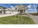 Two-story house with green and white siding, attached garage, and landscaped front yard at 39286 Hart Cir, Elizabeth, CO 80107