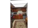 Kitchen with wood cabinets, stainless steel appliances, and patterned rug at 13901 E Marina Dr # 308, Aurora, CO 80014