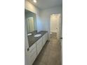 Bathroom with gray countertop, white cabinets, and tiled floor at 4859 Astor Pl, Brighton, CO 80601