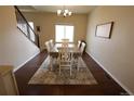 Bright dining room featuring hardwood floors and a spacious table with seating for six at 9023 Harlequin Cir, Longmont, CO 80504