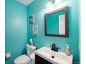 Small bathroom with teal walls, white sink, and dark brown vanity at 18689 E Powers Dr, Aurora, CO 80015