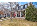 Two-story house with gray siding, brick accents, and a front porch at 18689 E Powers Dr, Aurora, CO 80015