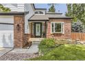 Inviting front entrance with a teal door, brick facade, and landscaping at 10752 Pikeview Ln, Parker, CO 80138