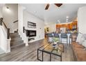 Living room featuring a fireplace, wood-style flooring, a staircase, and view of the kitchen at 6760 Fern Dr, Denver, CO 80221