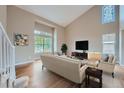 Spacious living room with hardwood floors, vaulted ceilings and a large window at 9357 Lark Sparrow Dr, Highlands Ranch, CO 80126