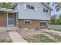 Partial view of brick and gray sided ranch home with walkway and landscaping at 10521 Inca St, Northglenn, CO 80234