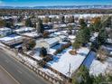 Aerial view showing a house with a large yard, a snow-covered lawn and mountain views in the background at 6101 S University Blvd, Centennial, CO 80121
