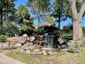 Peaceful waterfall feature with benches, surrounded by lush landscaping at 9995 E Harvard Ave # 179, Denver, CO 80231