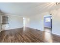 Spacious living room with polished hardwood floors and built-in shelving at 8610 Jolene Dr, Denver, CO 80229