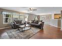 Open living room with hardwood floors, a cozy fireplace and view into kitchen at 1160 Cardinal Ave, Brighton, CO 80601