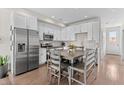 Modern kitchen with white cabinets, stainless steel appliances, and a breakfast bar at 1181 S Navajo St, Denver, CO 80223