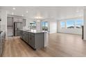 Modern kitchen with gray cabinets, island, and stainless steel appliances at 9314 Quartz St, Arvada, CO 80007