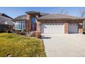 Two-story brick home with a three-car garage and landscaped yard at 6401 S Jamaica Cir, Englewood, CO 80111