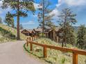 Luxury mountain home with long driveway and stone fence at 456 Crystal Ridge Rd, Evergreen, CO 80439