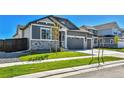 Two-story home with gray siding, stone accents, and a two-car garage at 9838 Danube St, Commerce City, CO 80022