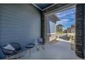 Covered patio with rocking chairs and small table at 18352 W 95Th Pl, Arvada, CO 80007