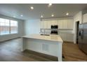 Modern kitchen with island and white cabinets at 1317 Sunrise Dr, Erie, CO 80516