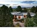 Modern home nestled amongst trees, showcasing architectural details and landscape at 3823 Castle Butte, Castle Rock, CO 80109
