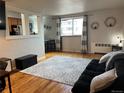 Living room with hardwood floors, a sofa, and a view into the kitchen area at 1350 Josephine St # 403, Denver, CO 80206