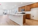 Modern kitchen with island, wood cabinets, and stainless steel appliances at 9743 Ceylon St, Commerce City, CO 80022