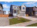 Two-story house with gray siding, a gray door, and a two-car garage at 13521 E 99Th Pl, Commerce City, CO 80022