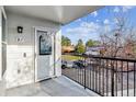 Balcony with a white door, black railing, and a view of the parking area at 1648 S Cole St # B7, Lakewood, CO 80228