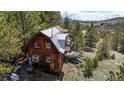Rustic cabin nestled in the mountains with a deck and surrounding trees at 131 Russel Gulch Rd, Central City, CO 80403