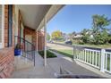 Brick home's front porch offers a view of the neighborhood at 652 Mountain Chickadee Rd, Highlands Ranch, CO 80126