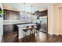 Modern kitchen with granite countertops, stainless steel appliances, and breakfast bar at 1854 Jules Ln, Louisville, CO 80027