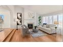 Spacious living room featuring hardwood floors, a cozy fireplace, and large windows at 8544 Burning Tree Trl, Franktown, CO 80116