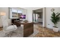 Bright home office features a desk, chair, and view into living area at 495 S Dayton St # 10C, Denver, CO 80247