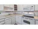 Kitchen with white cabinets, appliances, and tile floor at 495 S Dayton St # 10C, Denver, CO 80247