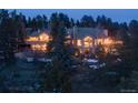 Luxury home nestled in a wooded area with mountain views at dusk at 1682 Montane E Dr, Golden, CO 80401