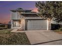 Two-story house with gray siding, stone accents, and a two-car garage at 4181 S Shawnee St, Aurora, CO 80018