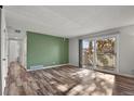 Living room with wood-look floors and access to balcony at 12100 Huron St # 201, Denver, CO 80234